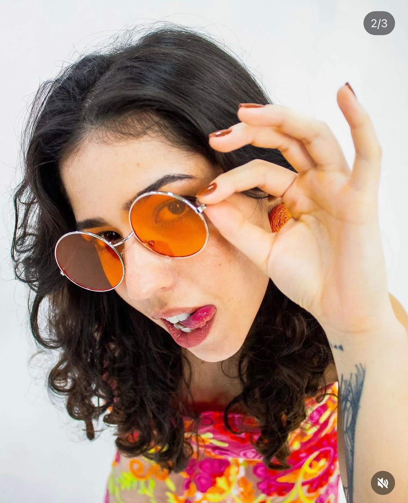Binova ajustando os óculos redondos laranja